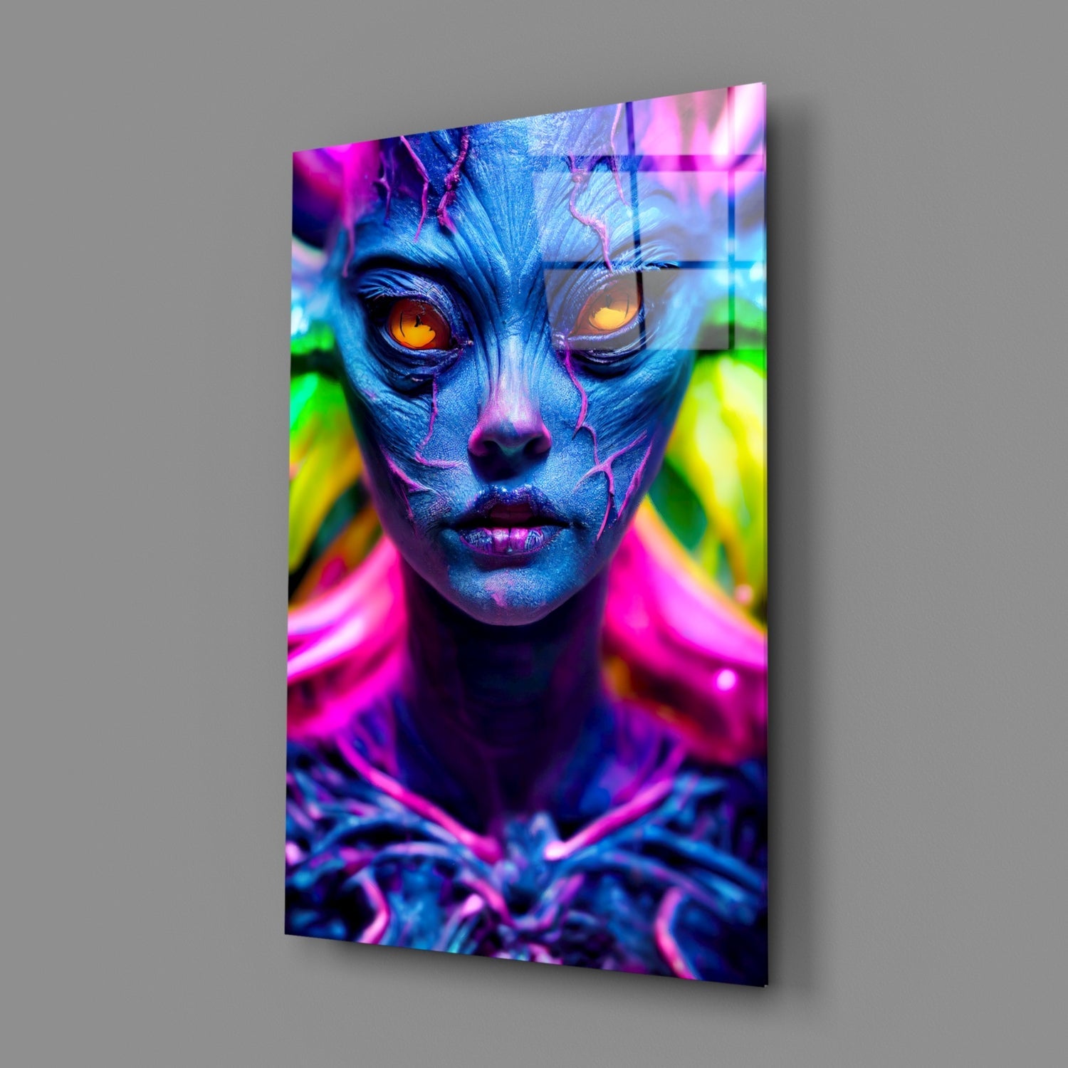 Blue face with orange eyes and neon pink, green, and yellow lighting effects on glass wall art panel, angled view.