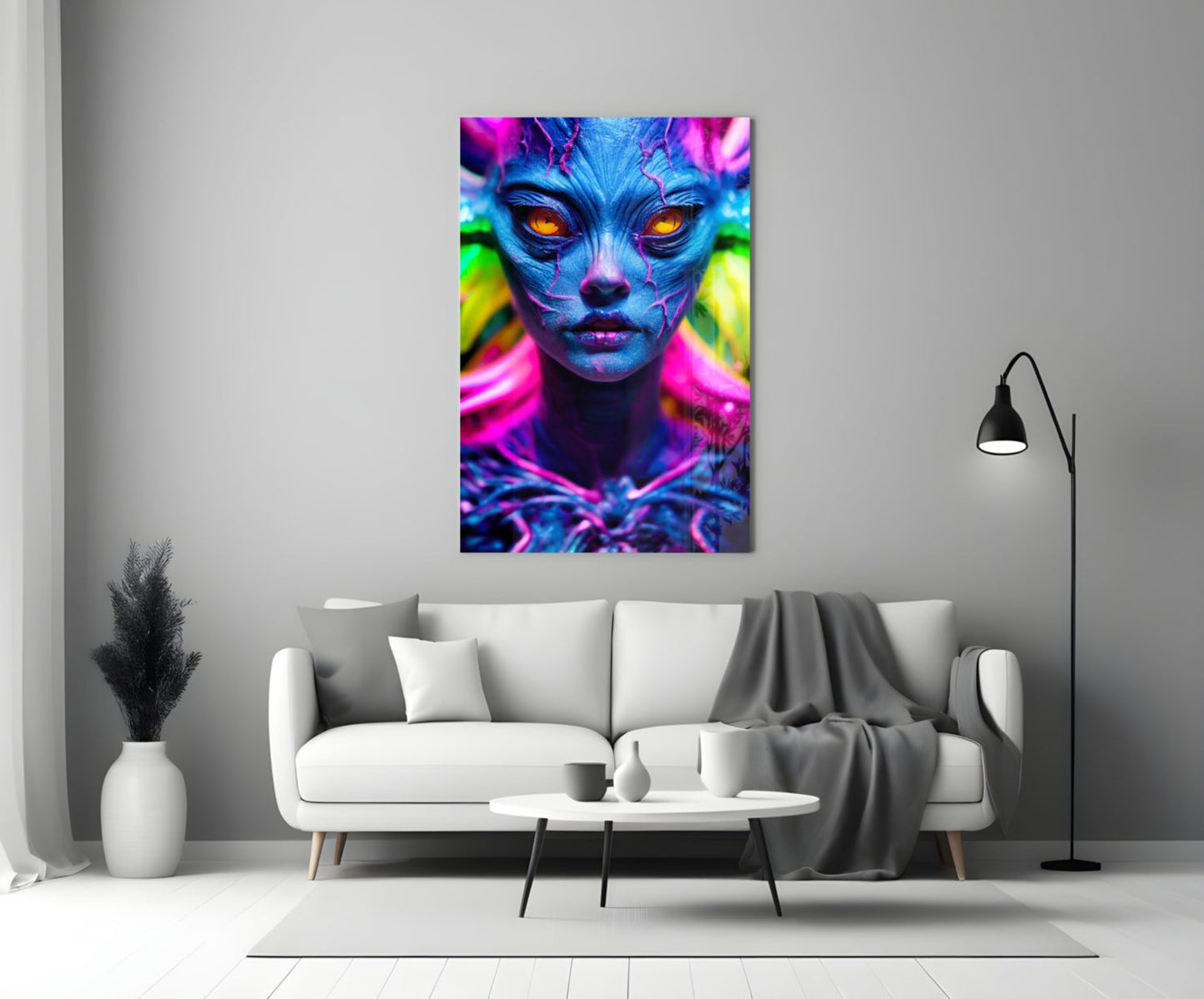 Neon blue alien face with glowing orange eyes and vibrant magenta and green lighting displayed as glass wall art above a white sofa.