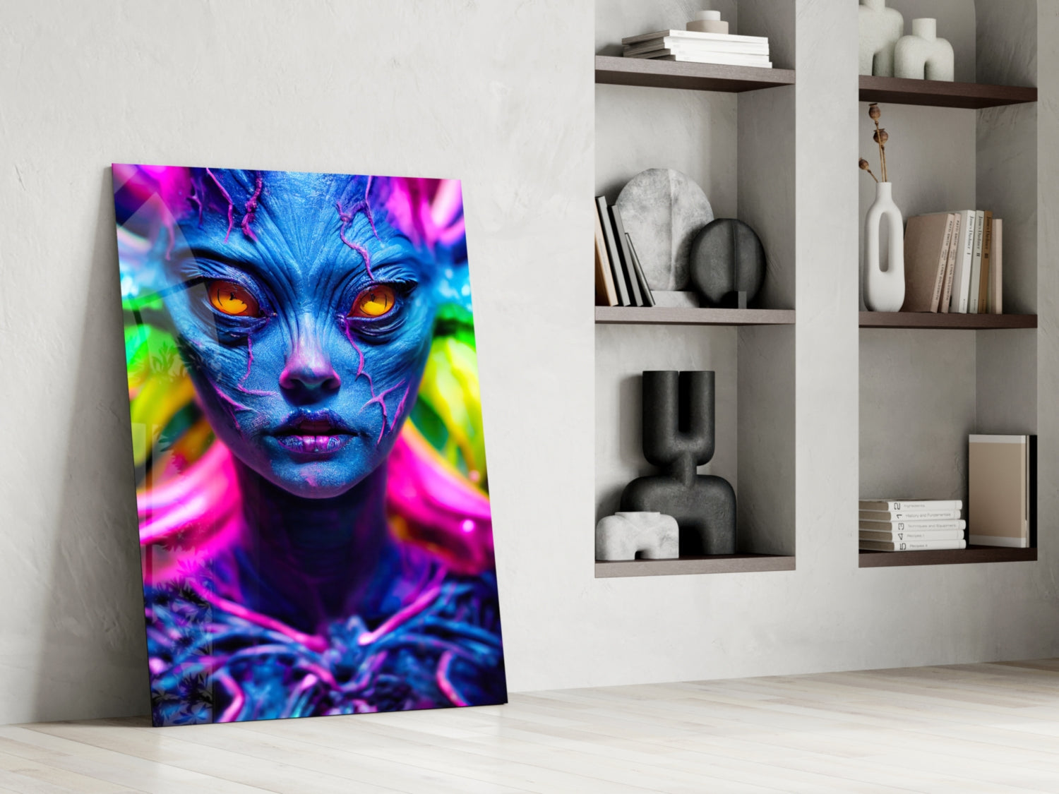 Vibrant neon glass wall art featuring blue face with glowing orange eyes and pink, magenta accents, leaning against white wall beside shelving.
