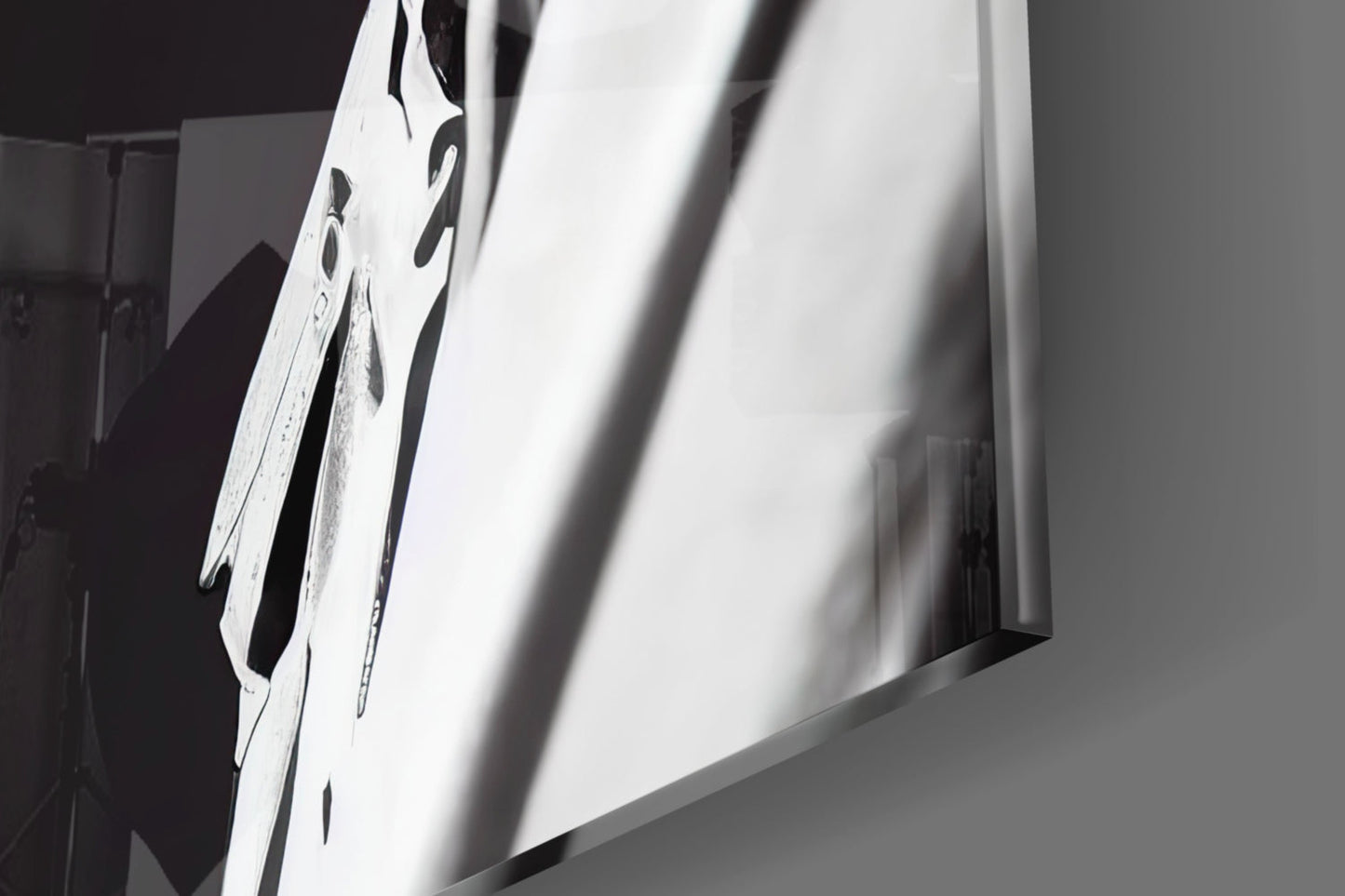 Close-up angled view of white glass art piece with black dragonfly designs and dramatic shadow cast across surface.