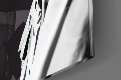 Close-up angled view of white glass art piece with black dragonfly designs and dramatic shadow cast across surface.