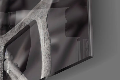 Close-up of weathered wooden frame detail against blurred glass art piece with neutral grey tones.