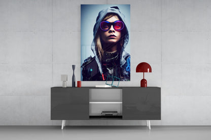 Futuristic portrait glass wall art featuring woman in pink sunglasses and hooded jacket, displayed above modern gray console table.