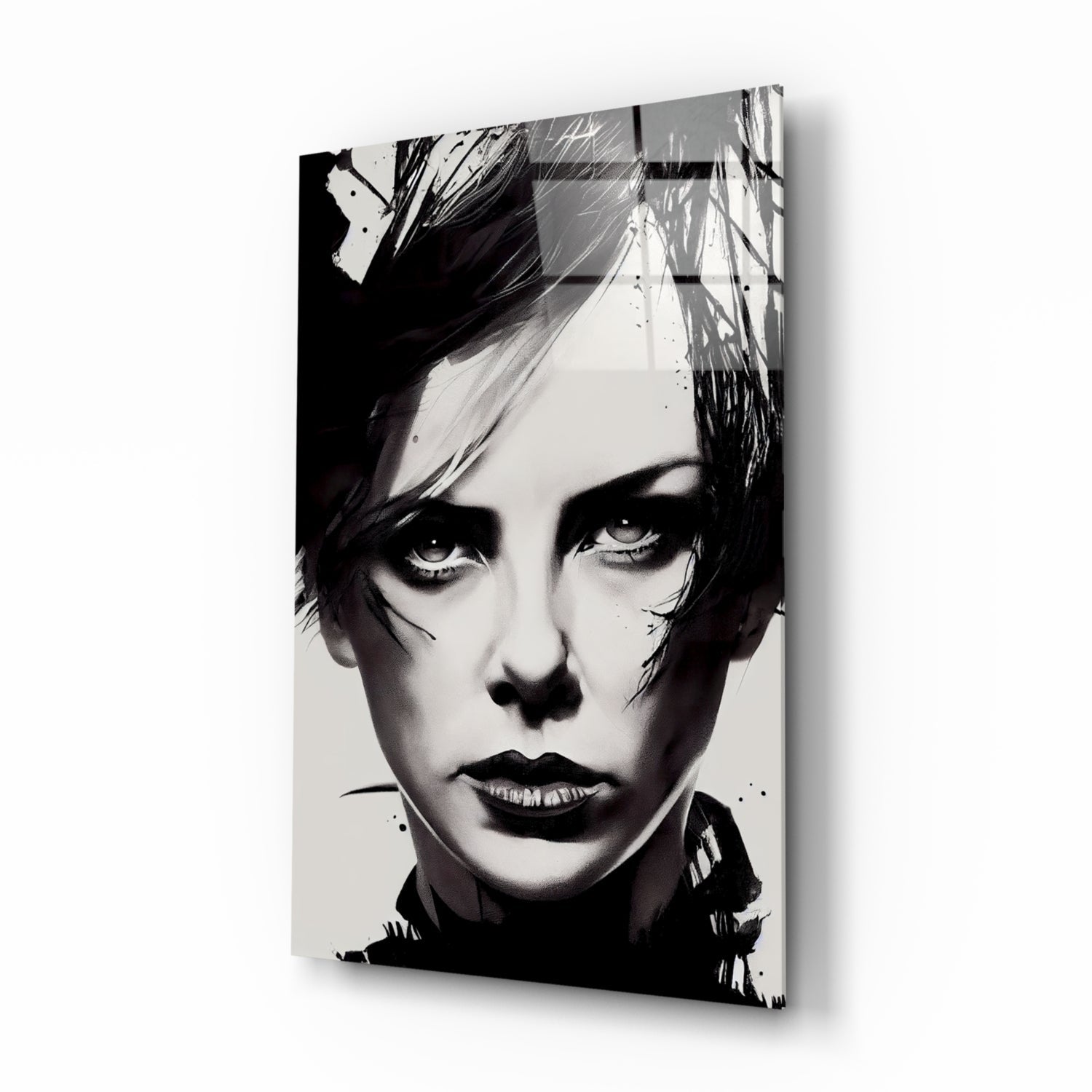 Black and white portrait on glass wall art showing a person with short dark hair and dramatic makeup, displayed at an angle against white background.