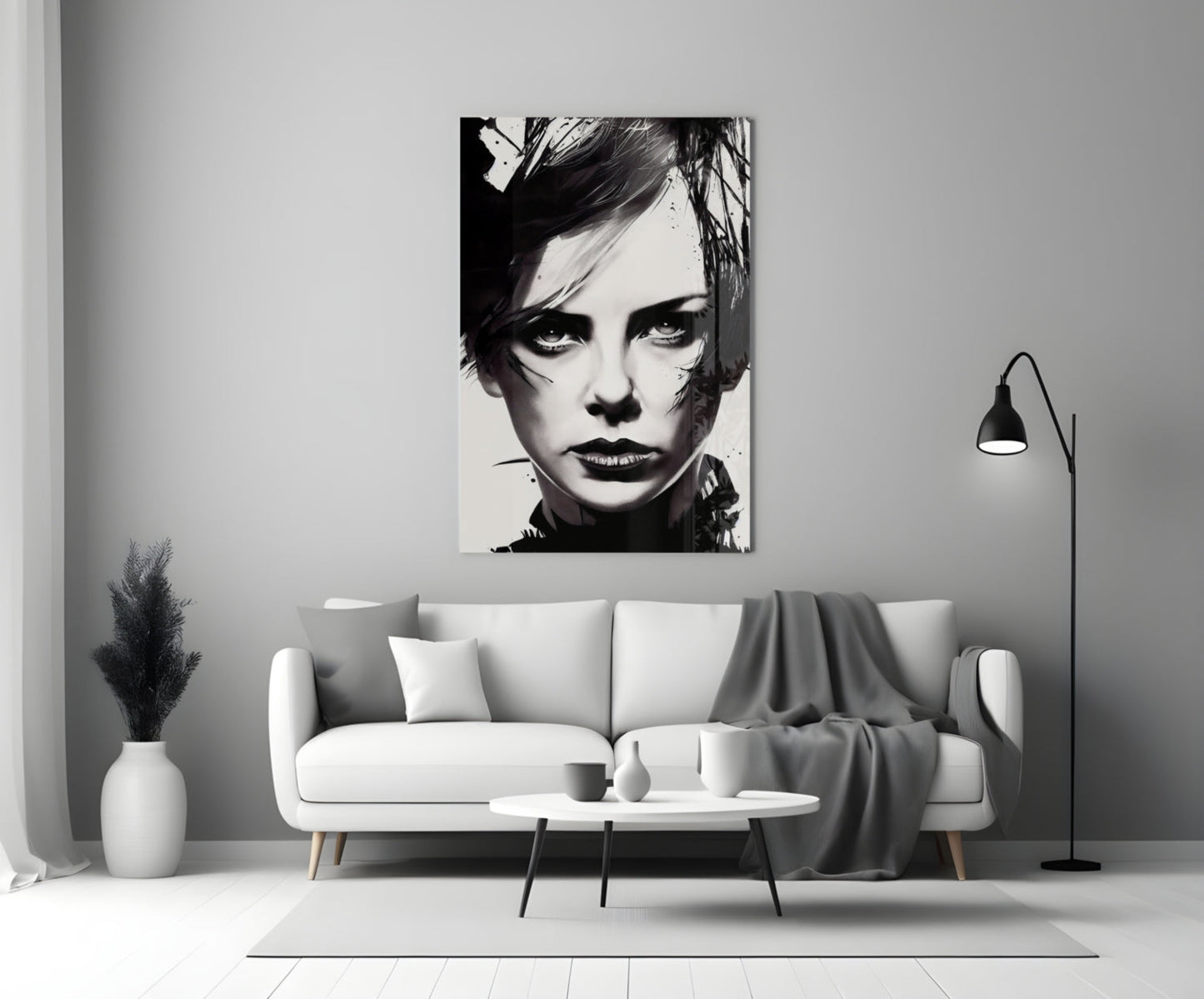 Black and white portrait glass wall art hanging above a white sofa in a minimalist living room setting.