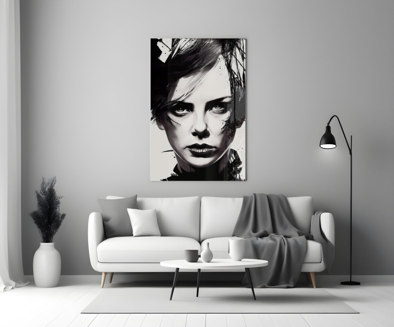 Black and white portrait glass wall art hanging above a white sofa in a minimalist living room setting.