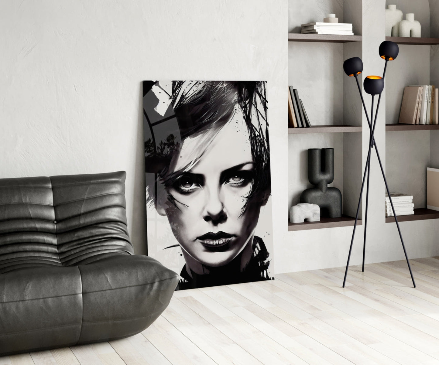 Modern living room interior featuring black and white portrait glass wall art displayed between gray leather furniture and floating shelves with decorative items.