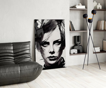 Modern living room interior featuring black and white portrait glass wall art displayed between gray leather furniture and floating shelves with decorative items.