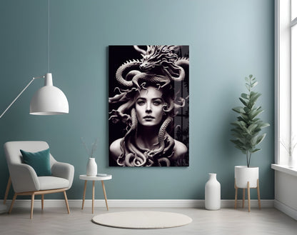 Black and white Medusa glass art print displayed on pale blue wall above white chair in minimalist room setting.