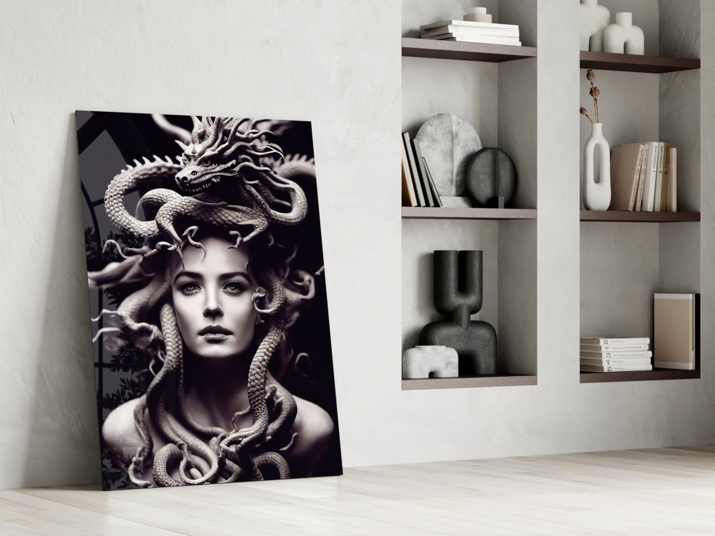 Black and white Medusa portrait glass art leaning against white wall beside floating shelves with decorative objects.