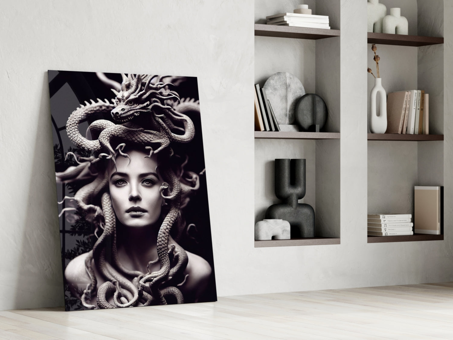 Black and white Medusa portrait glass art leaning against white wall beside floating shelves with decorative objects.