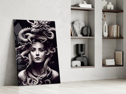Black and white Medusa portrait glass art leaning against white wall beside floating shelves with decorative objects.