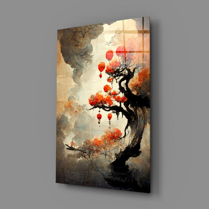 Glass art panel displaying gnarled tree with orange blossoms and red lanterns against misty landscape, mounted on gray wall.