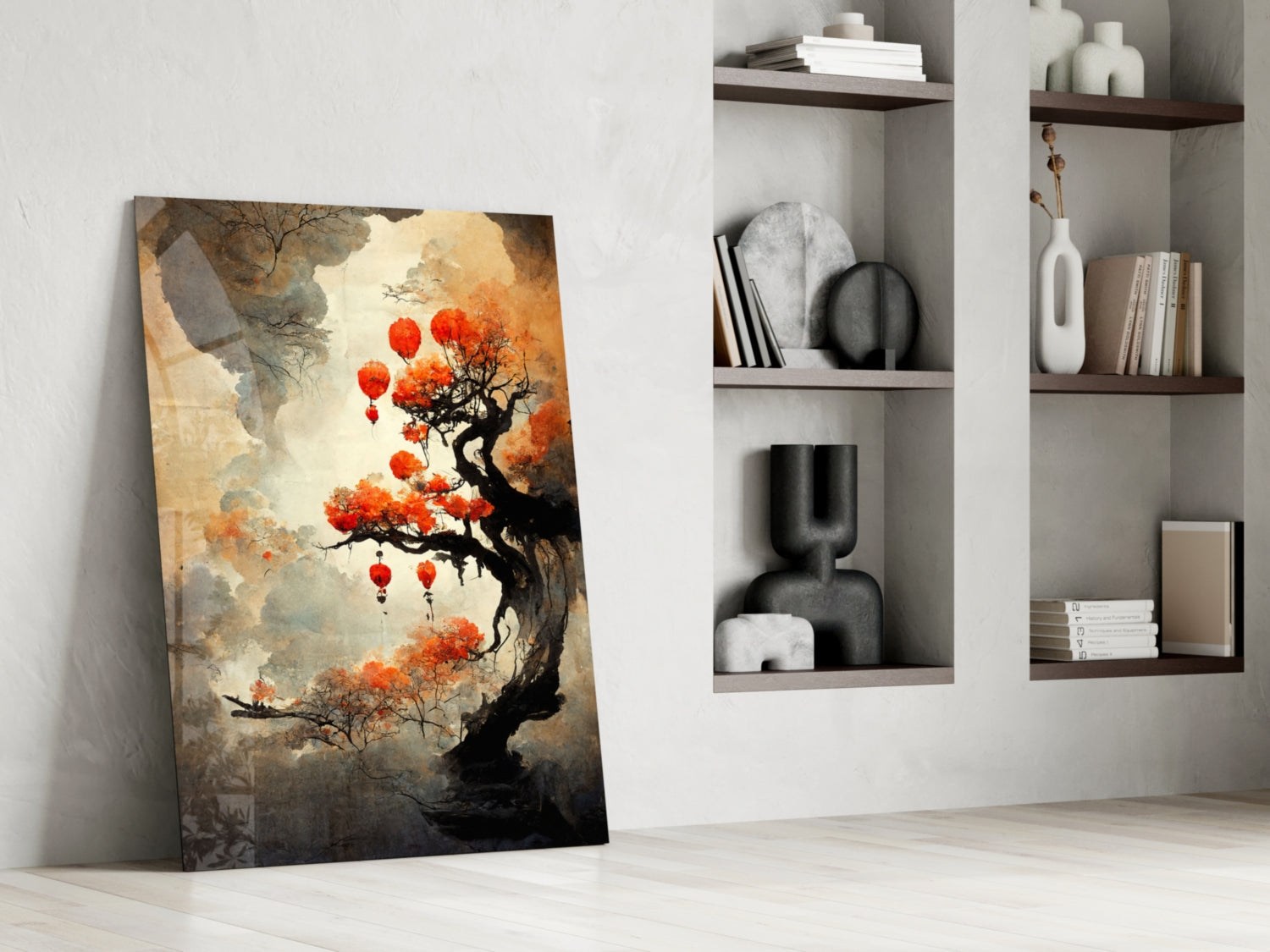 Glass art canvas leaning against white wall showing black gnarled tree with orange blossoms and red lanterns, displayed beside built-in shelving with decorative objects.