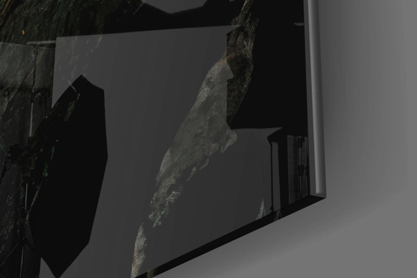 Close-up angled view of textured gray stone surface embedded in clear glass panel against white background.