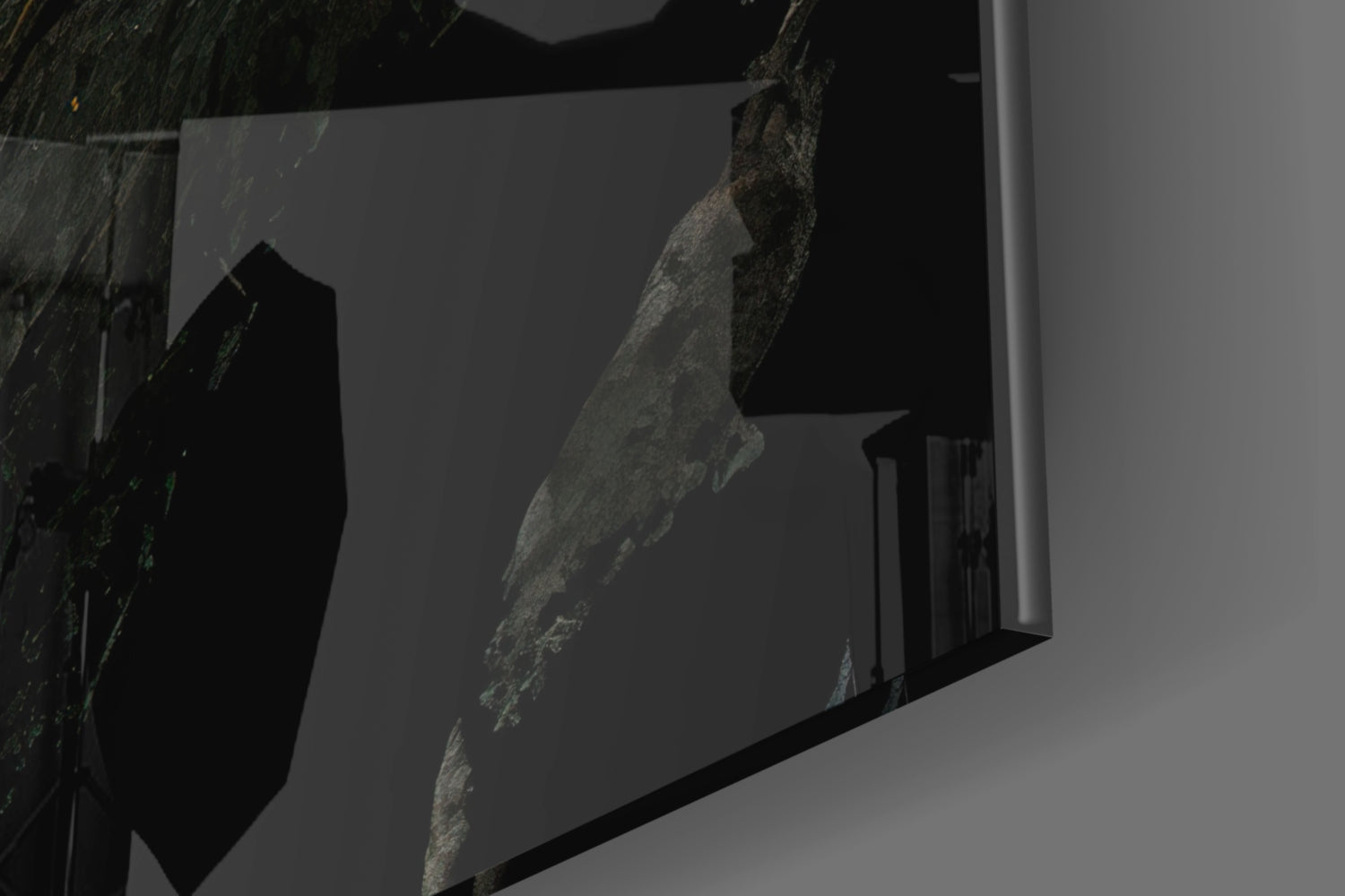 Close-up angled view of textured gray stone surface embedded in clear glass panel against white background.