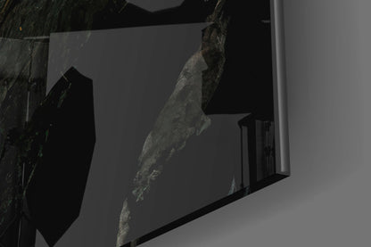 Close-up angled view of textured gray stone surface embedded in clear glass panel against white background.