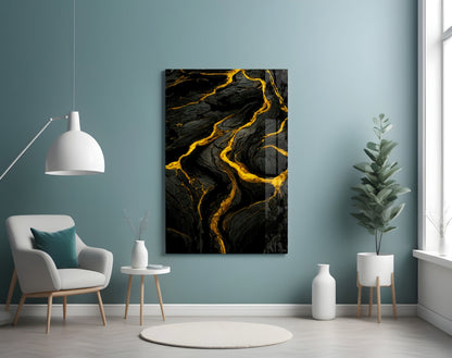 Black and gold marbled slit glass art panel displayed on a teal wall above a white armchair in a modern interior setting.