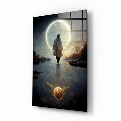 Solitary figure in hooded coat standing in shallow water facing enormous glowing moon, autumn trees reflected below, glass wall art displayed at angle.