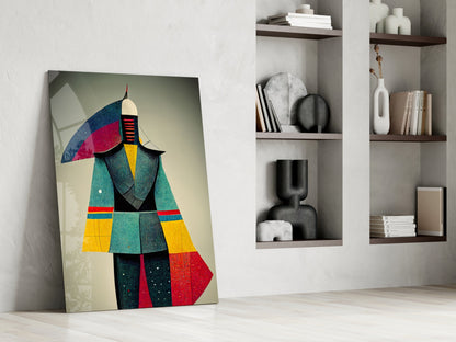 Colorful geometric art print leaning against white wall beside shelving unit displaying decorative objects and books.