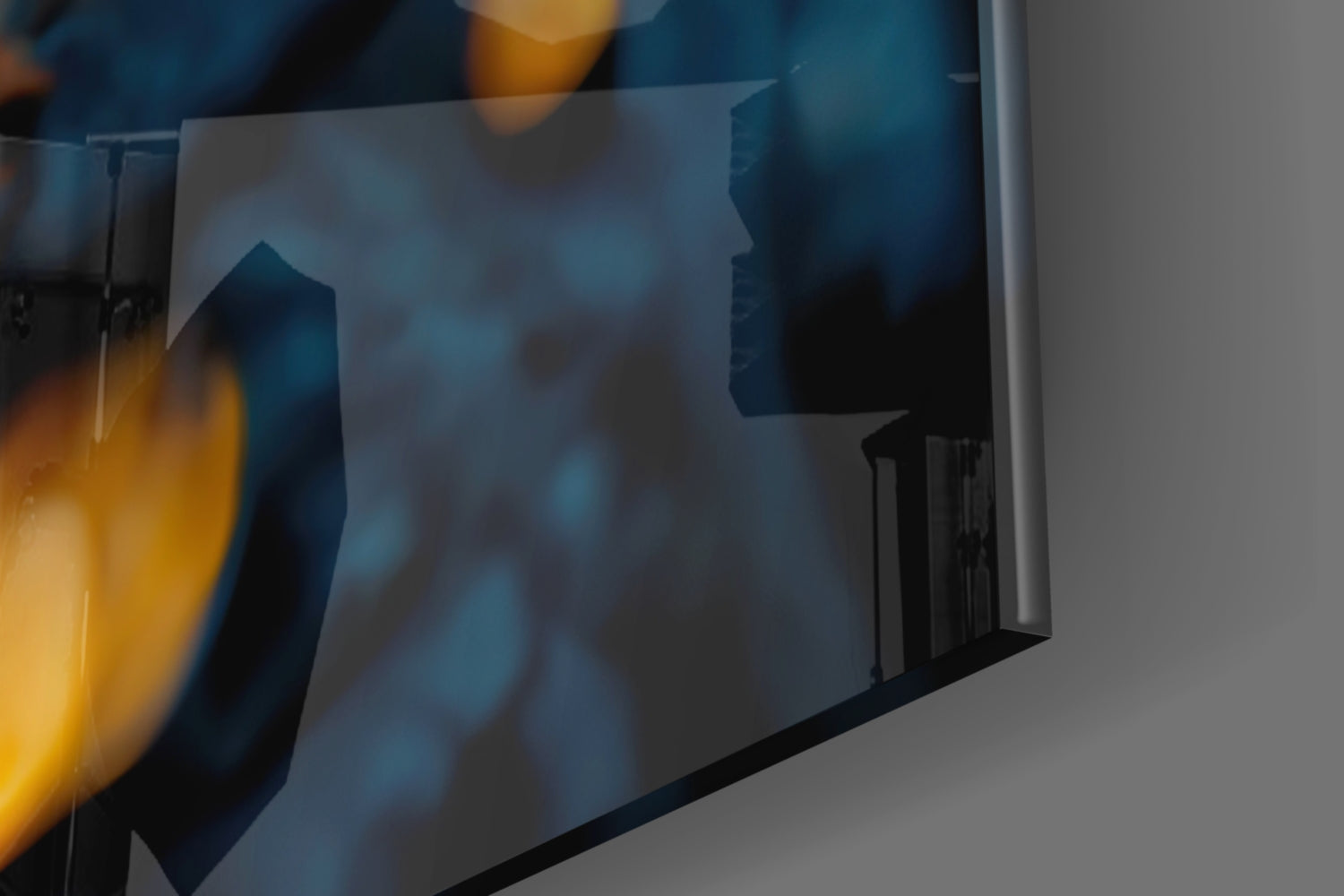 Close-up angled view of translucent glass art with blue and golden yellow tones, showing silhouetted profile and architectural details.
