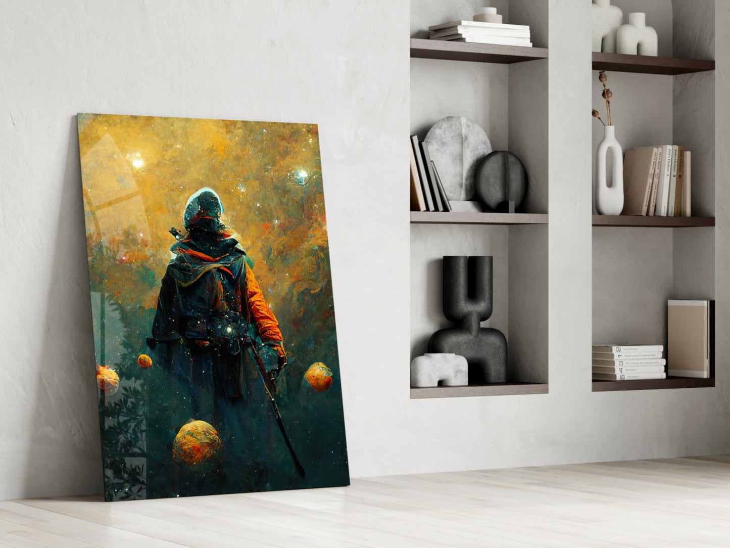 Glass wall art leaning against white wall displays figure in dark clothing surrounded by golden spheres against teal and gold background.