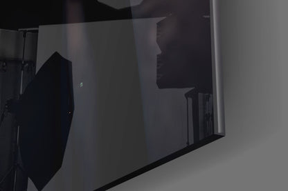 Silhouettes of two people visible through frosted glass panels with black frame dividers in interior space.