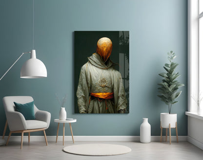 Headless Monk glass art displayed on teal wall above white chair, showing golden spherical head and cream robe with orange sash.
