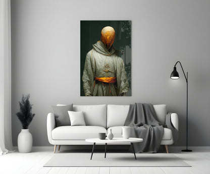 Headless Monk glass art depicting golden glowing orb head with cross symbol, cream robes, and orange belt, displayed above white sofa in modern interior.