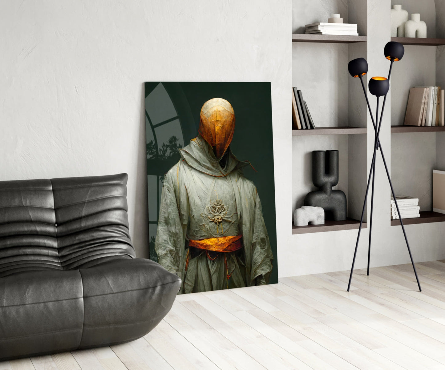 Headless Monk glass art depicting golden spherical head with cross, cream robes and orange sash, displayed in modern living room beside gray sofa.