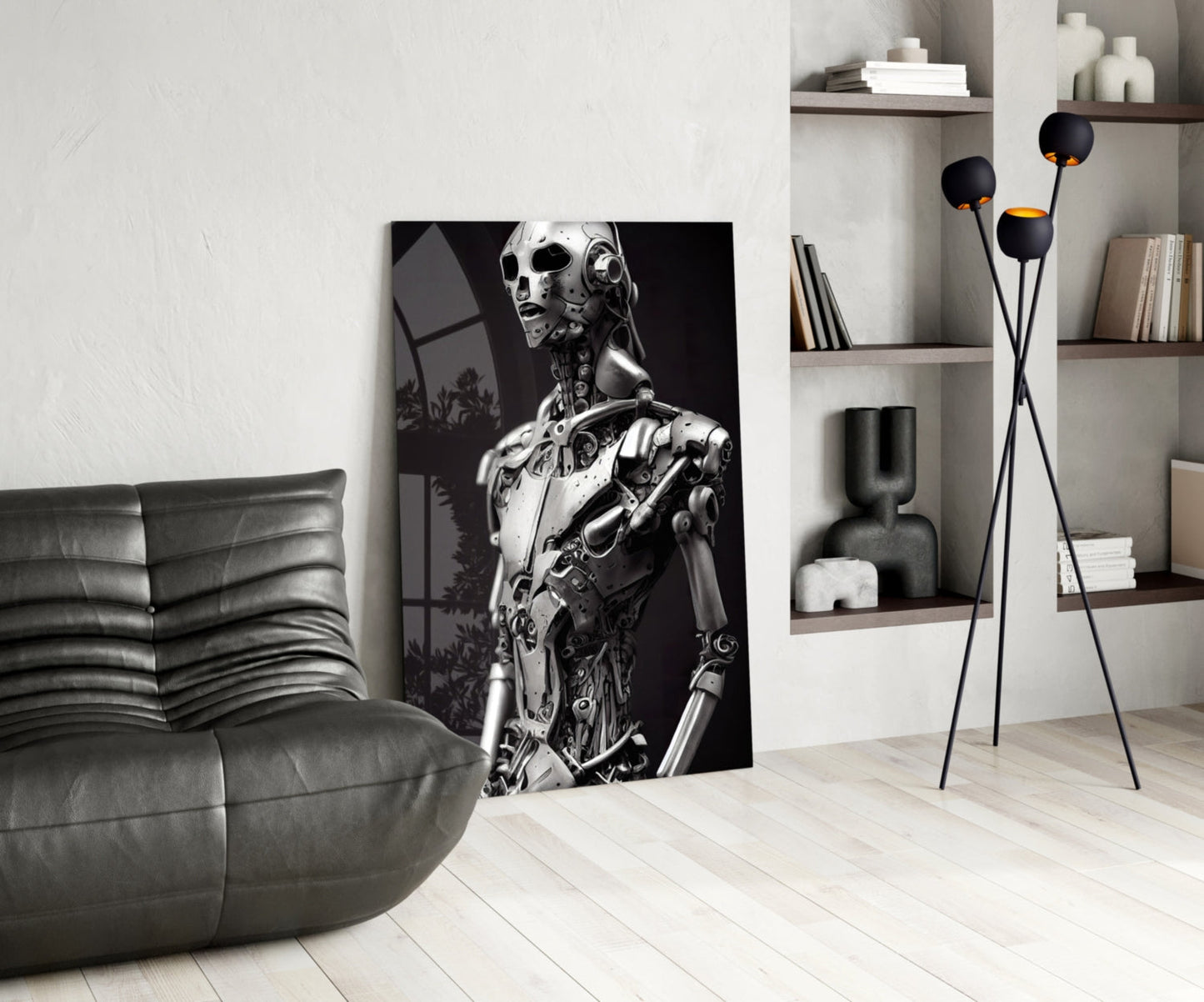 Modern living room interior featuring a monochromatic robot portrait artwork leaning against white wall beside gray leather sofa.