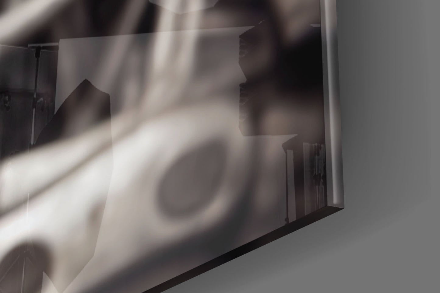 Close-up detail of frosted glass wall art showing blurred silhouettes and light rays through translucent surface.