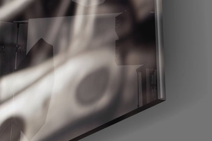 Close-up detail of frosted glass wall art showing blurred silhouettes and light rays through translucent surface.