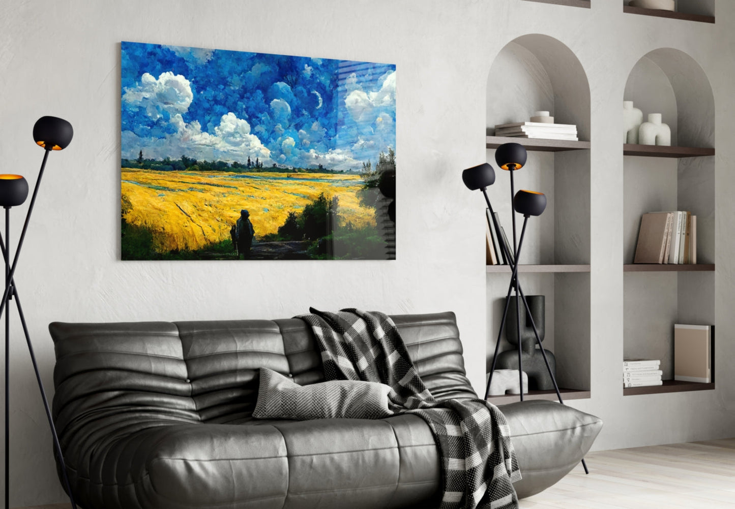 Vibrant landscape glass art depicting golden wheat field and blue sky displayed above black leather sofa in modern living room.