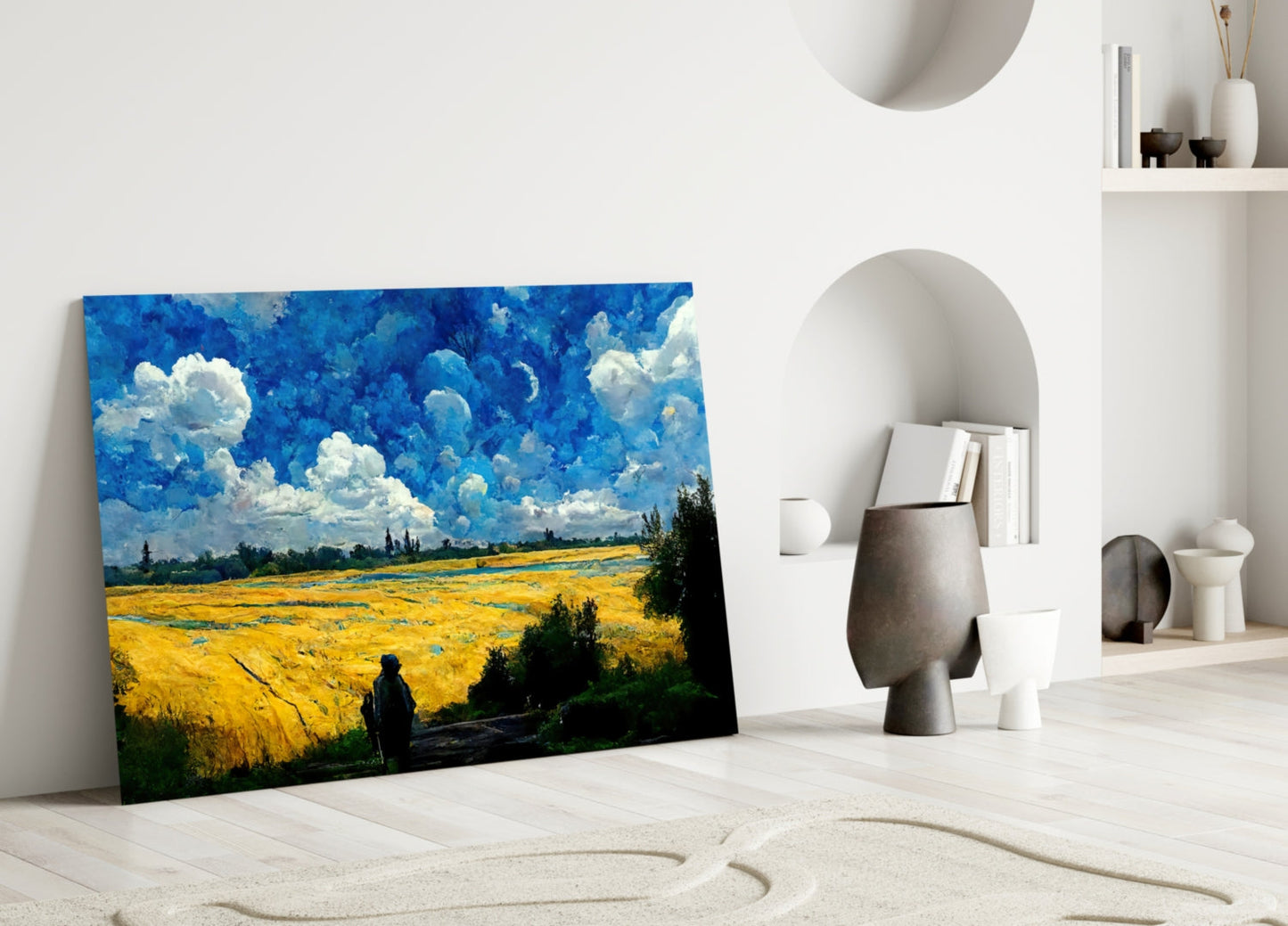 Landscape glass art depicting a golden wheat field under a dramatic blue sky with white clouds, leaning against a white wall in a minimalist room setting.