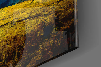 Close-up angled view of Dancing Sky Glass Art showing yellow and dark brown textured glass surface with blue tones visible at top edge.