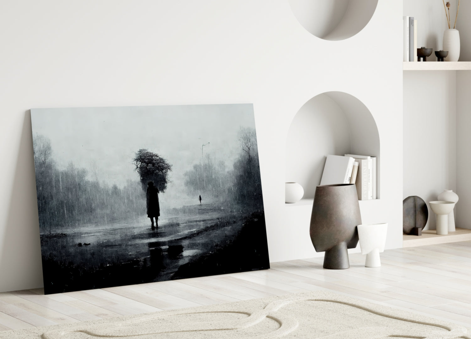 Moody black and white glass art leaning against white wall depicting solitary figure in rainy landscape with bare trees.