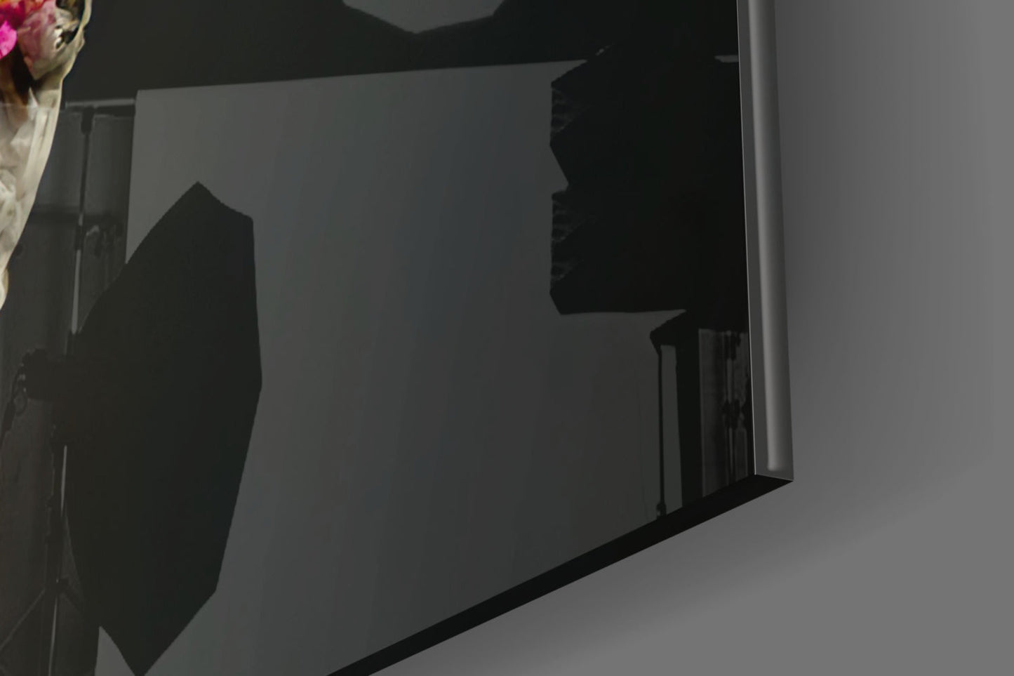 Side view of black glass art sculpture with silhouetted figure against translucent panel, white wall background.