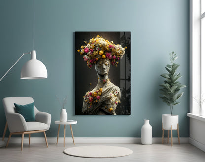 Classical statue bust adorned with vibrant yellow, pink, and white flowers displayed on gallery wall above modern chair.