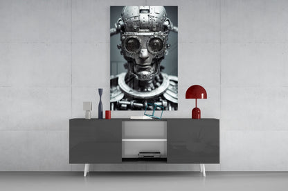 Monochrome mechanical robot head with circular lens eyes displayed on a dark console shelf with red decorative accessories and white wall background.