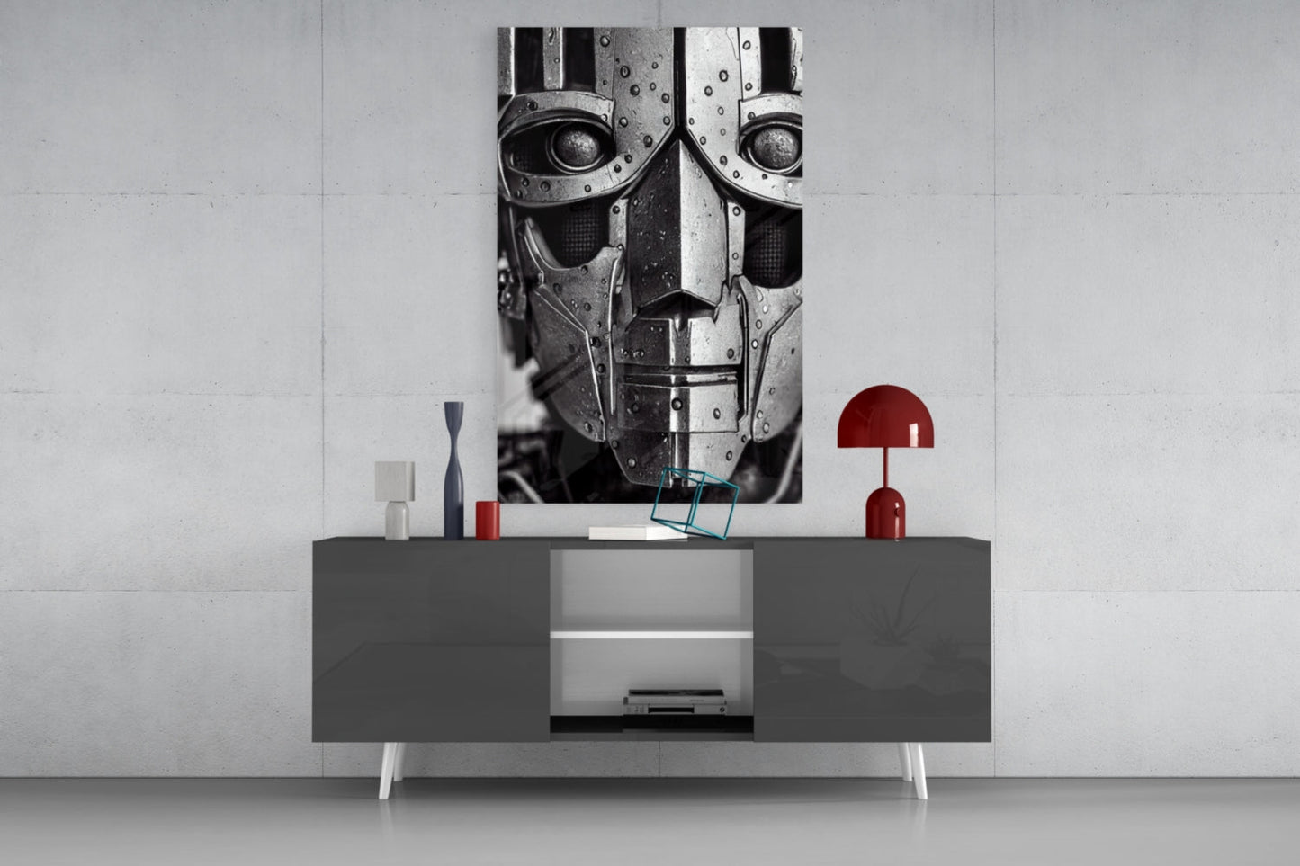 Modern living room display featuring a dark gray media console with white legs beneath a monochromatic robotic head artwork and red decorative accessories.
