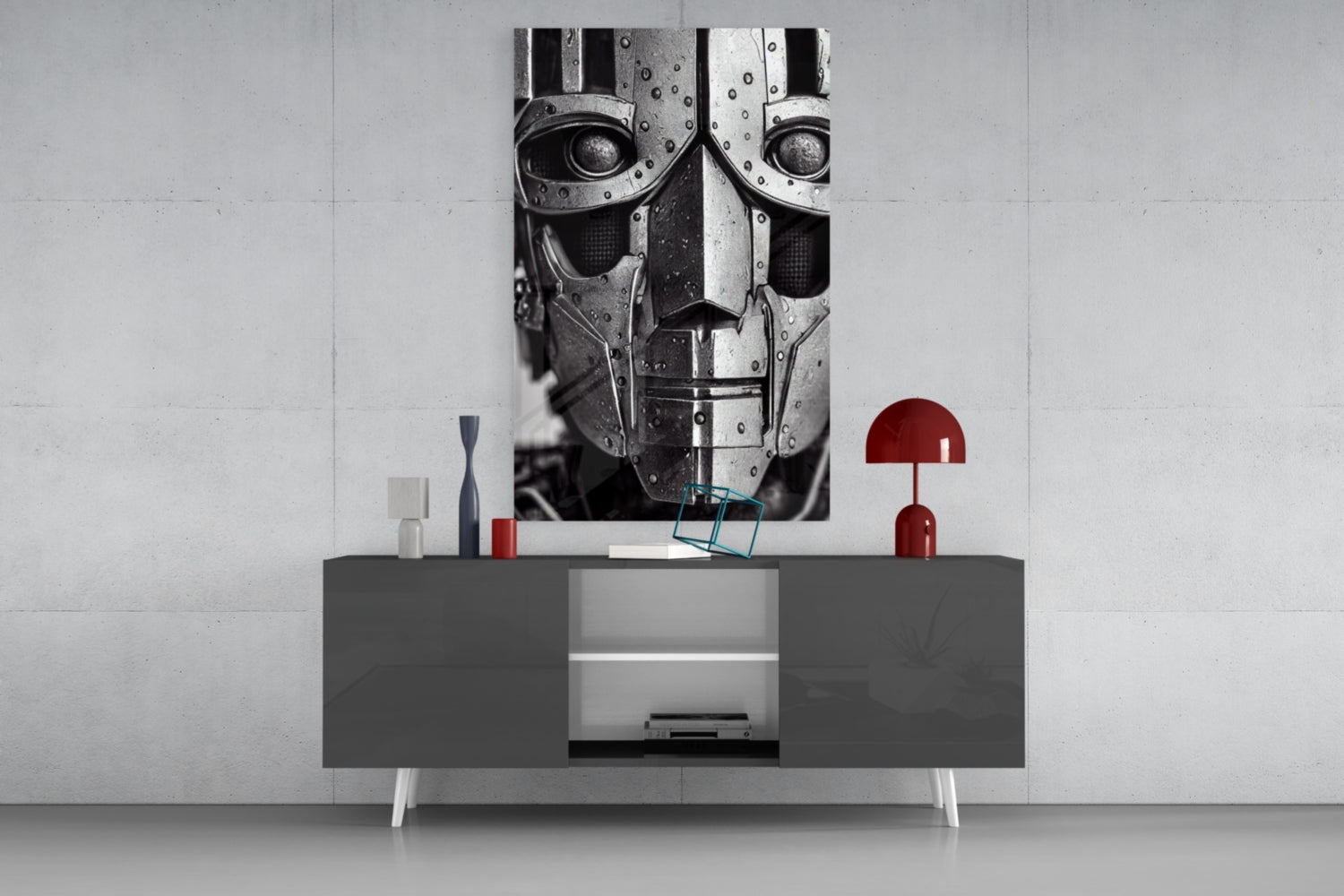 Modern living room display featuring a dark gray media console with white legs beneath a monochromatic robotic head artwork and red decorative accessories.