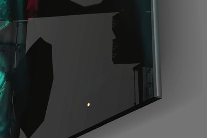 Dark silhouette of Prince Glass Wall Art mounted on gray wall, photographed at angle with single light reflection visible.