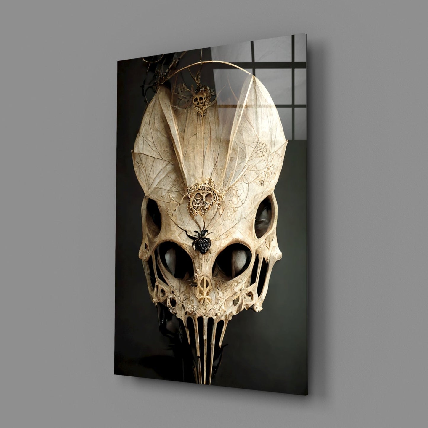 Ornate cream skull glass art with delicate filigree details and translucent wing-like structures mounted on dark background.