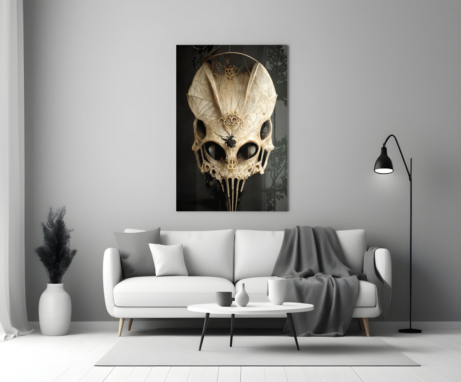 Ornate ivory skull glass art with intricate filigree detailing displayed on white living room wall above sofa.