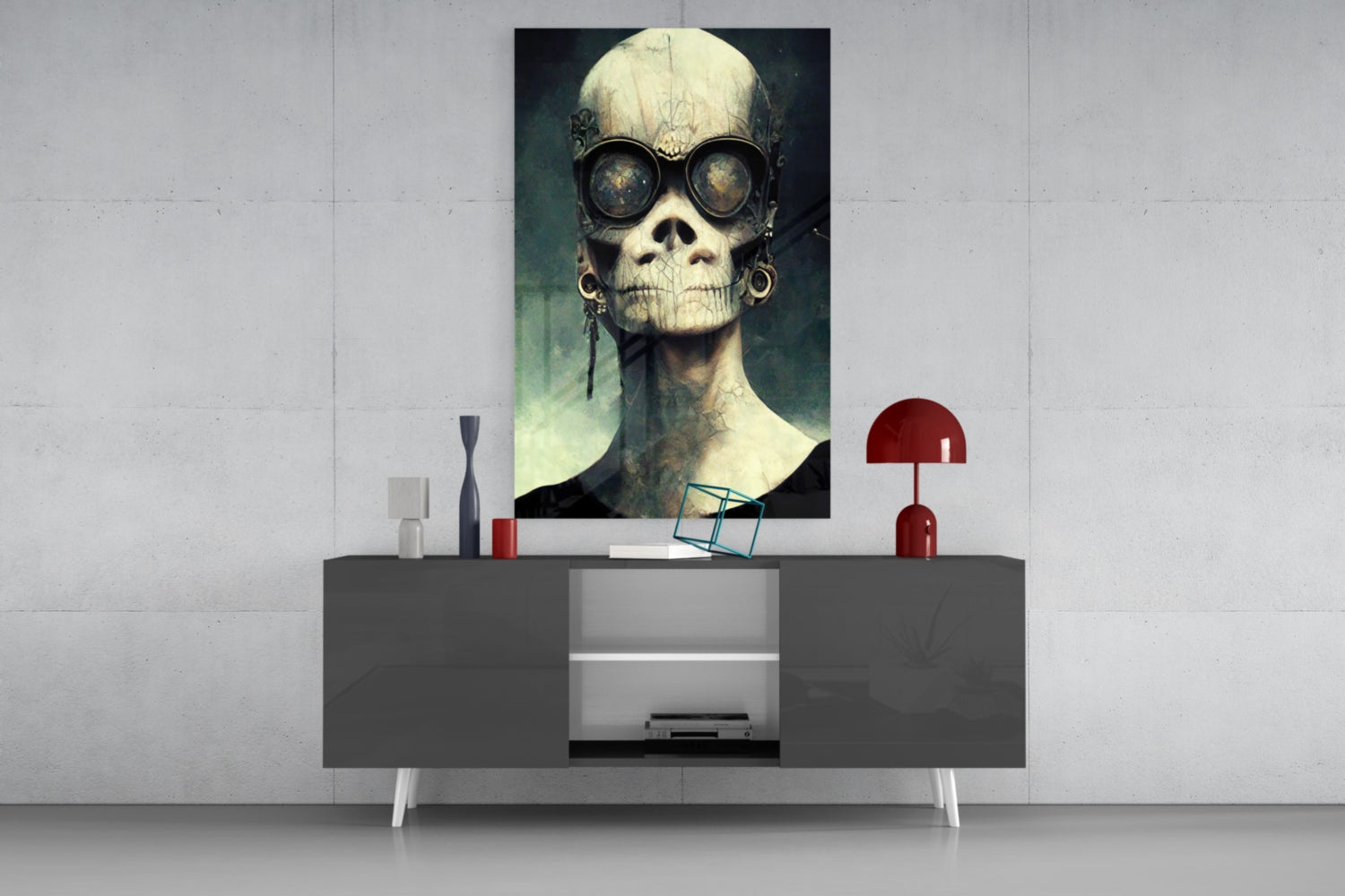 Skull-faced figure wearing steampunk goggles displayed as framed glass art above modern console table with red lamp and decorative objects.