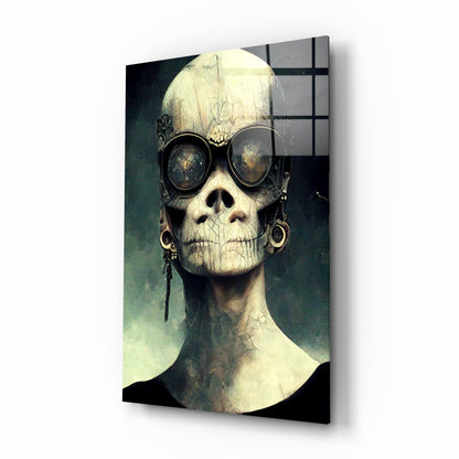 Stylized skull portrait wearing round dark goggles and dangling earrings against teal and cream gradient background on glass panel.