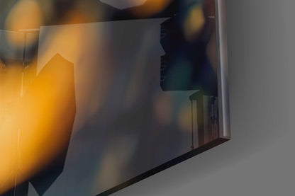 Close-up of amber and clear glass art piece with warm golden light illuminating translucent surfaces and geometric forms.