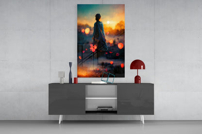 Glass wall art displaying silhouetted figure against golden sunset with floating red bokeh lights, displayed above modern gray console table.