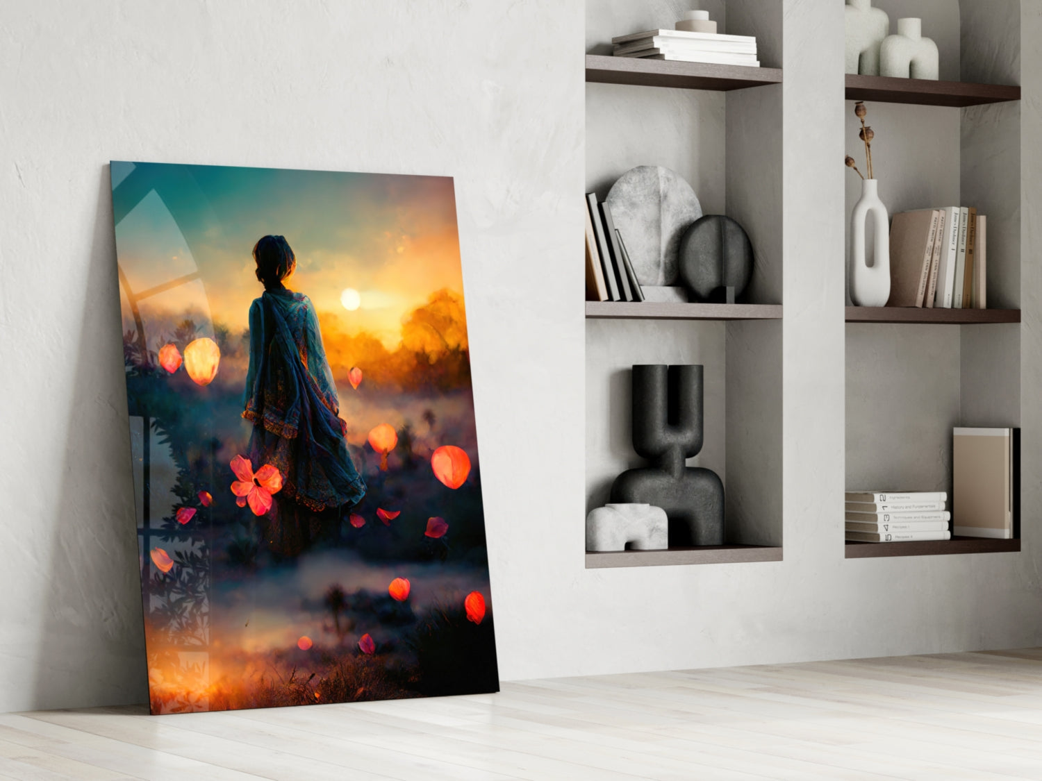 Glass wall art leaning against white wall showing woman in blue clothing facing sunset with glowing orange flowers and bokeh lights.